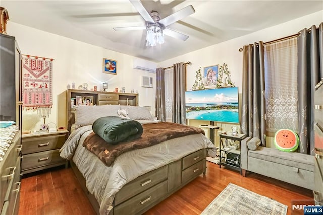 bedroom featuring dark wood finished floors, a wall mounted air conditioner, and ceiling fan