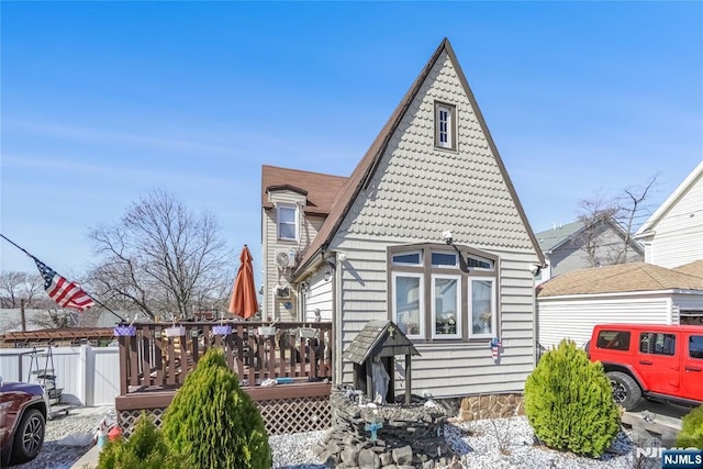 rear view of property featuring a deck and fence