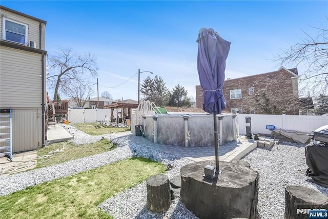 view of yard with a fenced in pool, a wooden deck, and a fenced backyard