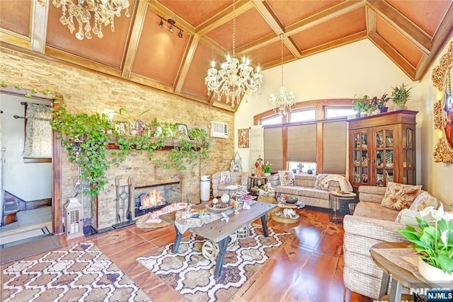 living room with a chandelier, a lit fireplace, wood finished floors, coffered ceiling, and high vaulted ceiling