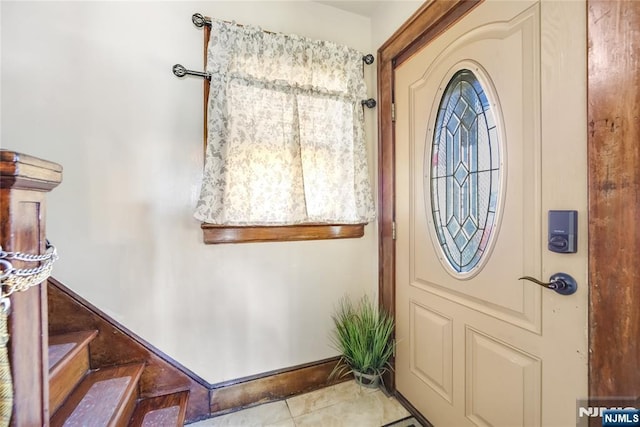 foyer entrance featuring stairs, baseboards, and tile patterned flooring