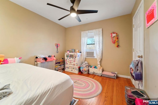 bedroom with a ceiling fan, baseboards, and wood finished floors