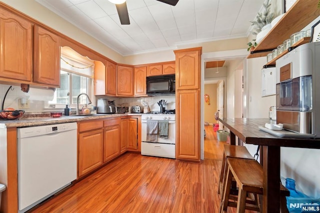 kitchen with tasteful backsplash, ceiling fan, light wood-style floors, white appliances, and a sink