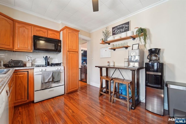 kitchen featuring dark wood-type flooring, crown molding, decorative backsplash, brown cabinets, and white appliances