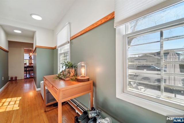 corridor with baseboards and wood finished floors