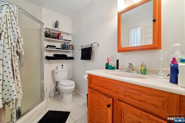 bathroom with toilet, a stall shower, tile patterned flooring, baseboards, and vanity