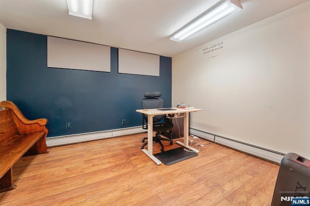 home office with a baseboard heating unit and wood finished floors