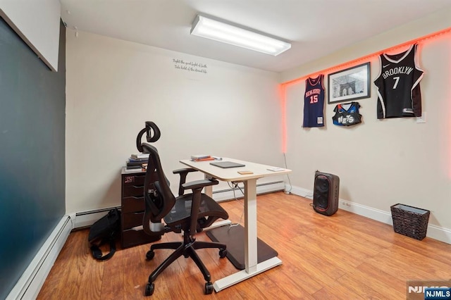 office featuring wood finished floors, baseboards, and a baseboard radiator