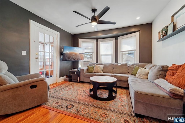 living room with plenty of natural light, baseboards, ceiling fan, and wood finished floors