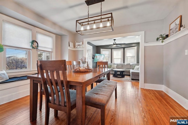 dining area featuring light wood finished floors, baseboards, and a ceiling fan