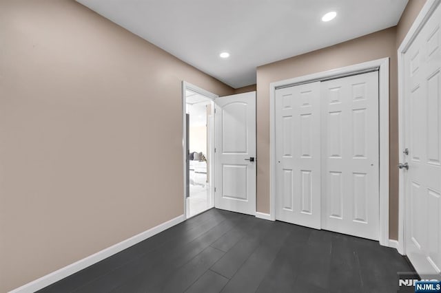 unfurnished bedroom featuring recessed lighting, a closet, baseboards, and dark wood-style flooring