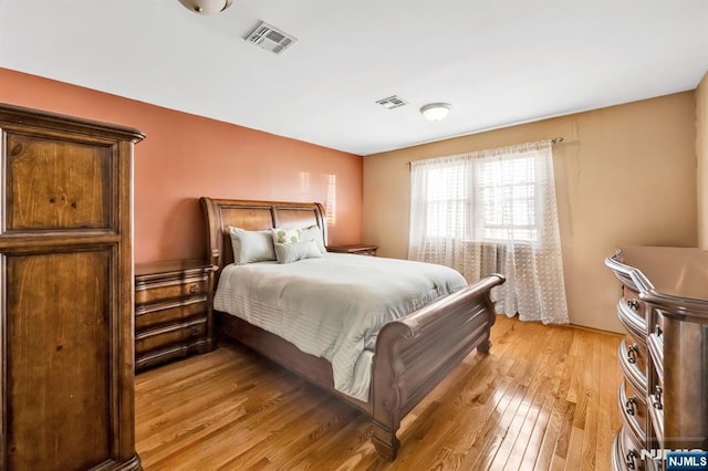 bedroom featuring light wood-style flooring and visible vents