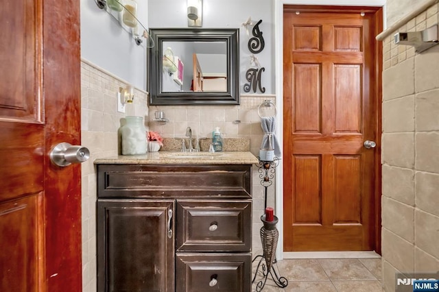 bathroom with tile patterned flooring, tile walls, and vanity