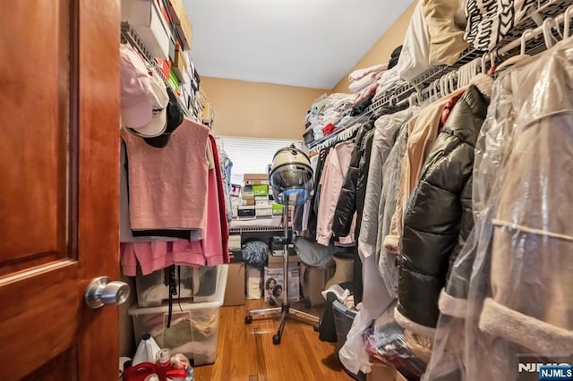 walk in closet with wood finished floors