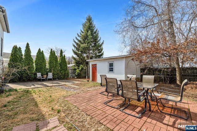 view of patio featuring an outdoor structure and a fenced backyard