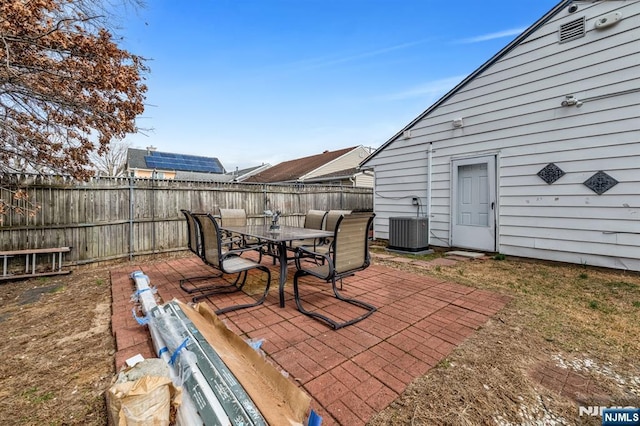 view of patio featuring outdoor dining area, cooling unit, and a fenced backyard