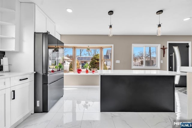 kitchen featuring open shelves, plenty of natural light, freestanding refrigerator, light countertops, and marble finish floor