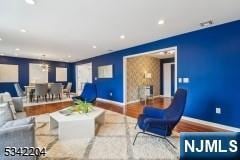 sunken living room featuring recessed lighting, baseboards, wood finished floors, and an accent wall