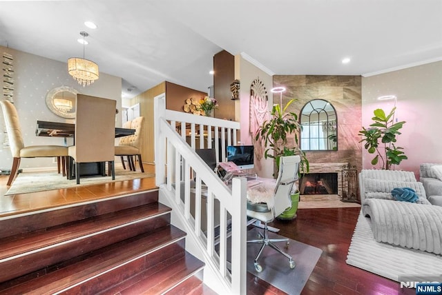 living area featuring recessed lighting, ornamental molding, a fireplace, and wood finished floors