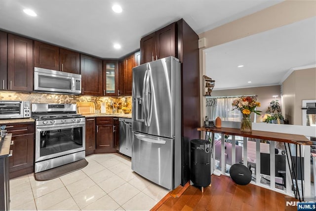 kitchen featuring light tile patterned floors, stainless steel appliances, backsplash, and a toaster