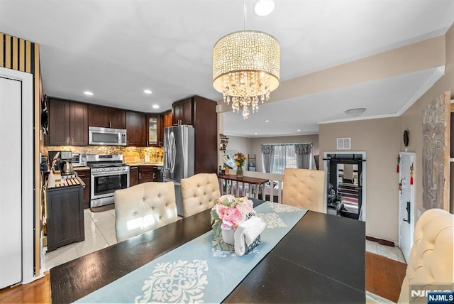 dining area featuring visible vents, ornamental molding, light tile patterned floors, recessed lighting, and an inviting chandelier