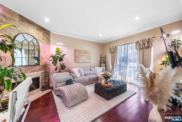 living area featuring a fireplace, crown molding, recessed lighting, and wood finished floors