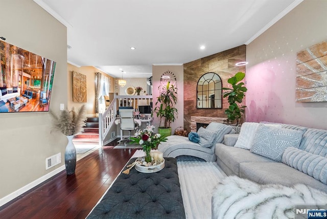 living room with visible vents, hardwood / wood-style flooring, crown molding, baseboards, and stairs