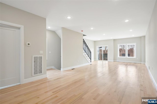 unfurnished living room with stairway, recessed lighting, visible vents, and light wood-type flooring