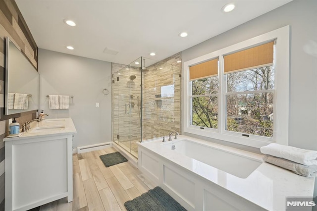 bathroom with a shower stall, wood tiled floor, recessed lighting, a bath, and a baseboard radiator