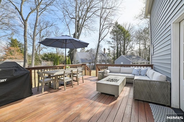 deck featuring an outdoor living space with a fire pit, area for grilling, and outdoor dining space