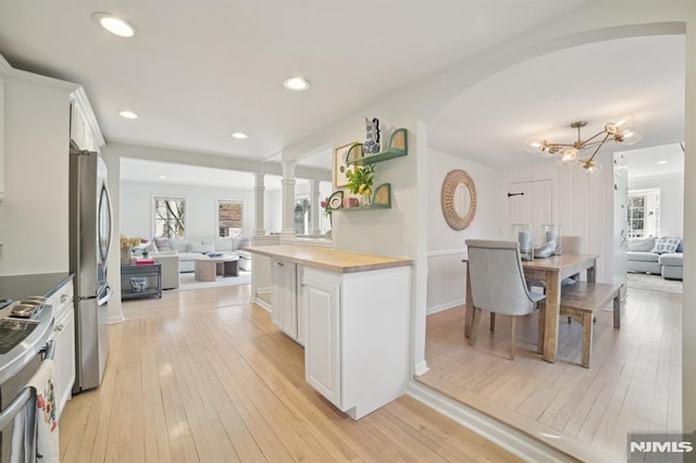 kitchen featuring range, wooden counters, open floor plan, and light wood-style flooring