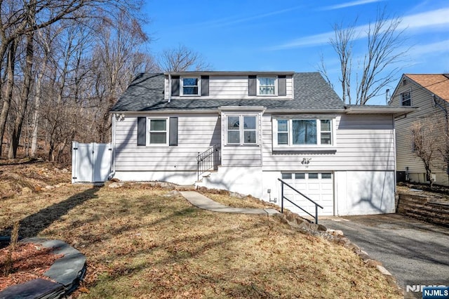 view of front facade featuring a garage, aphalt driveway, and a shingled roof