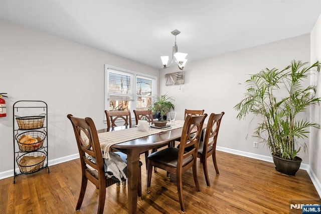 dining area with a chandelier, baseboards, and wood finished floors