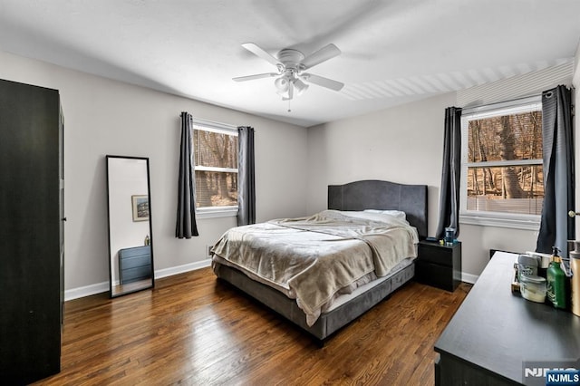 bedroom with ceiling fan, baseboards, and dark wood-style floors