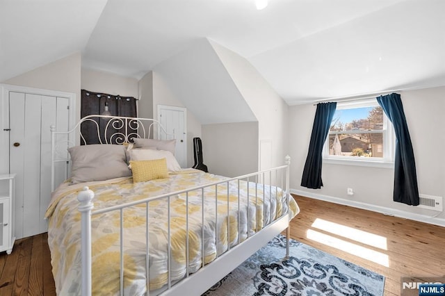 bedroom featuring vaulted ceiling, baseboards, and wood finished floors