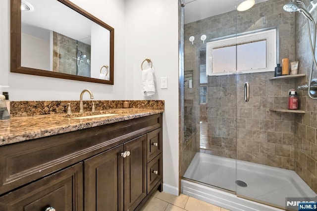 full bath featuring a stall shower, vanity, and tile patterned flooring