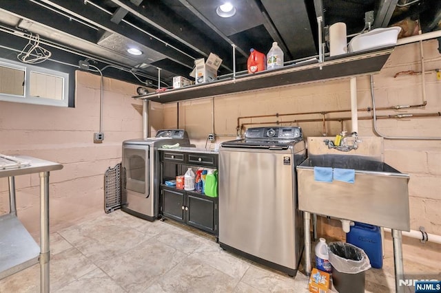 washroom with a sink, laundry area, and washer and clothes dryer