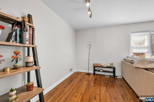 interior space with rail lighting, wood finished floors, visible vents, and baseboards