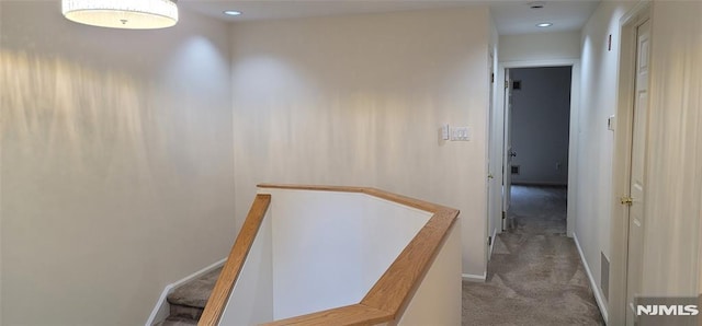 corridor featuring an upstairs landing, baseboards, and carpet