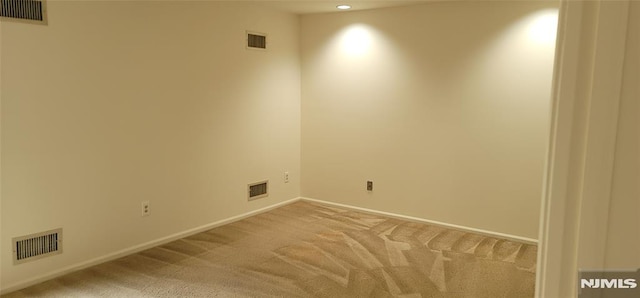 spare room with visible vents and light carpet