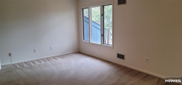 unfurnished room with visible vents, carpet flooring, and baseboards