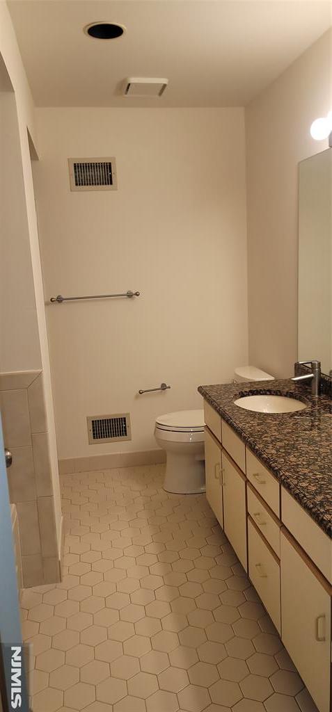 bathroom featuring visible vents, toilet, and vanity