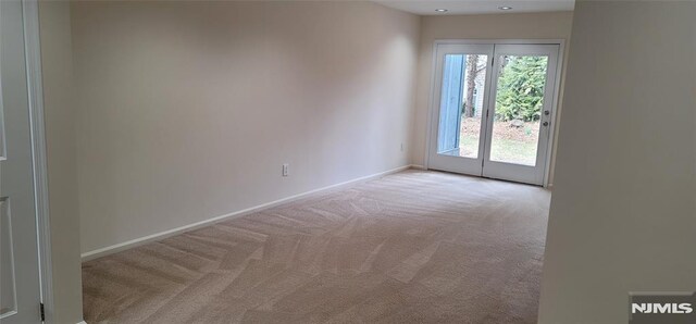 spare room featuring baseboards and carpet flooring