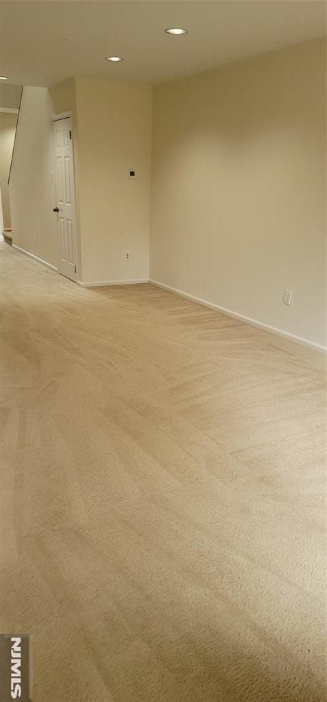 empty room with recessed lighting, baseboards, and light carpet