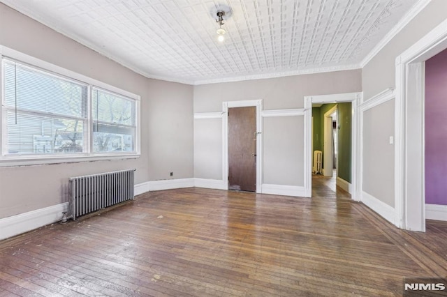 interior space with baseboards, radiator, hardwood / wood-style floors, and ornamental molding