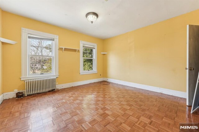 empty room with radiator and baseboards