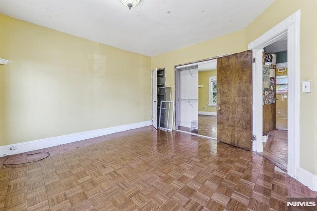 empty room with a barn door and baseboards