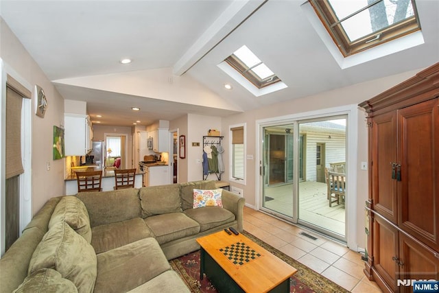 living room featuring lofted ceiling with skylight, light tile patterned floors, recessed lighting, and visible vents