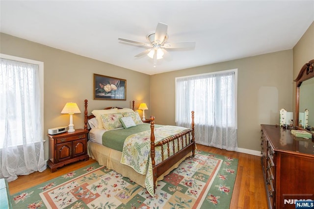 bedroom with baseboards, ceiling fan, and light wood finished floors