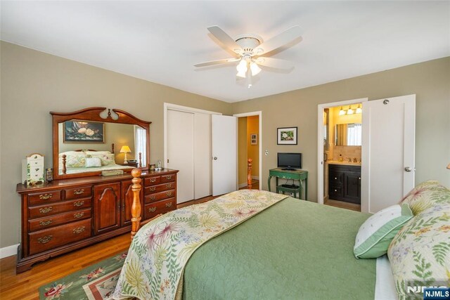 bedroom featuring connected bathroom, baseboards, ceiling fan, wood finished floors, and a closet